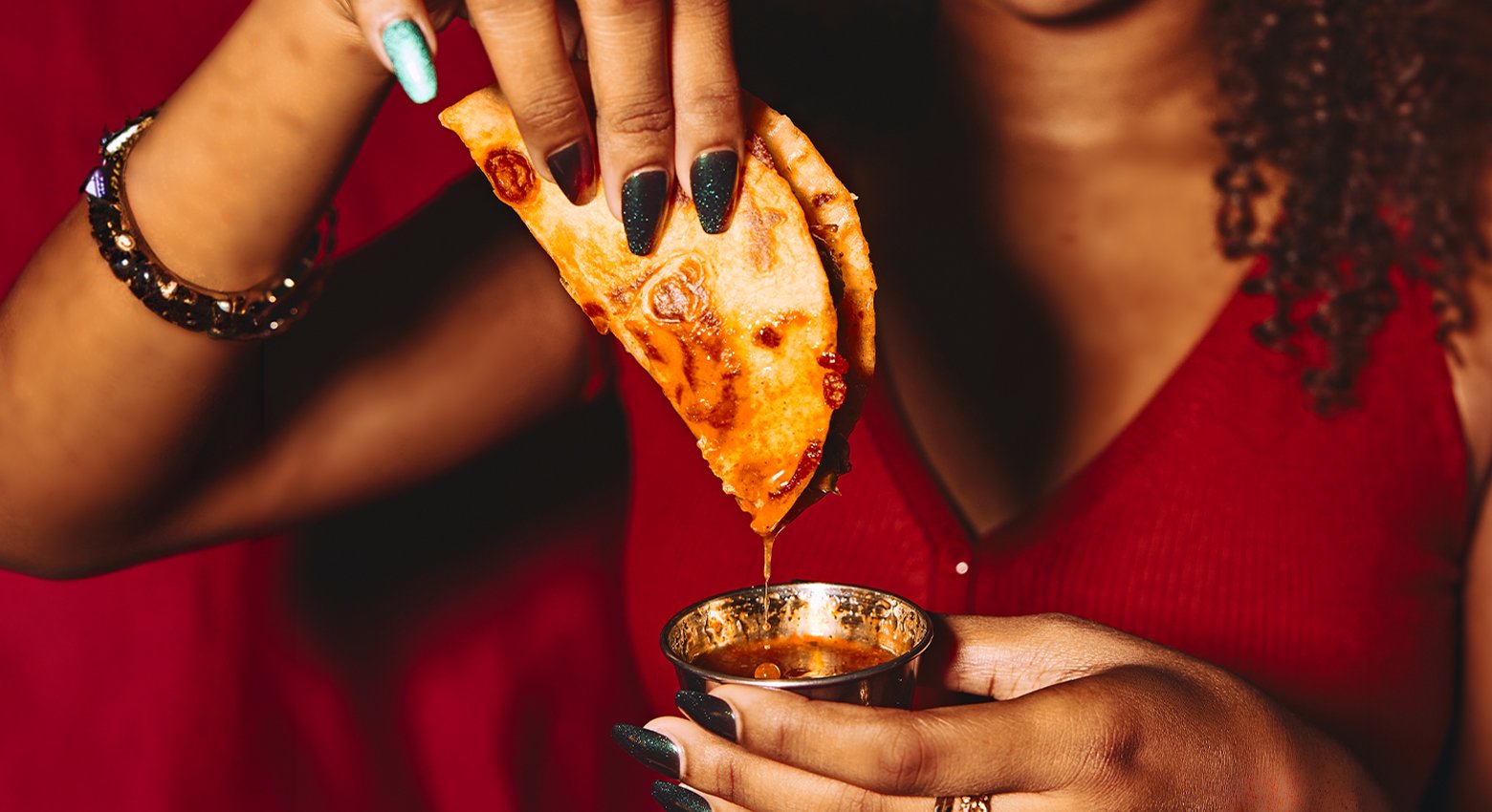 Person dipping taco into sauce